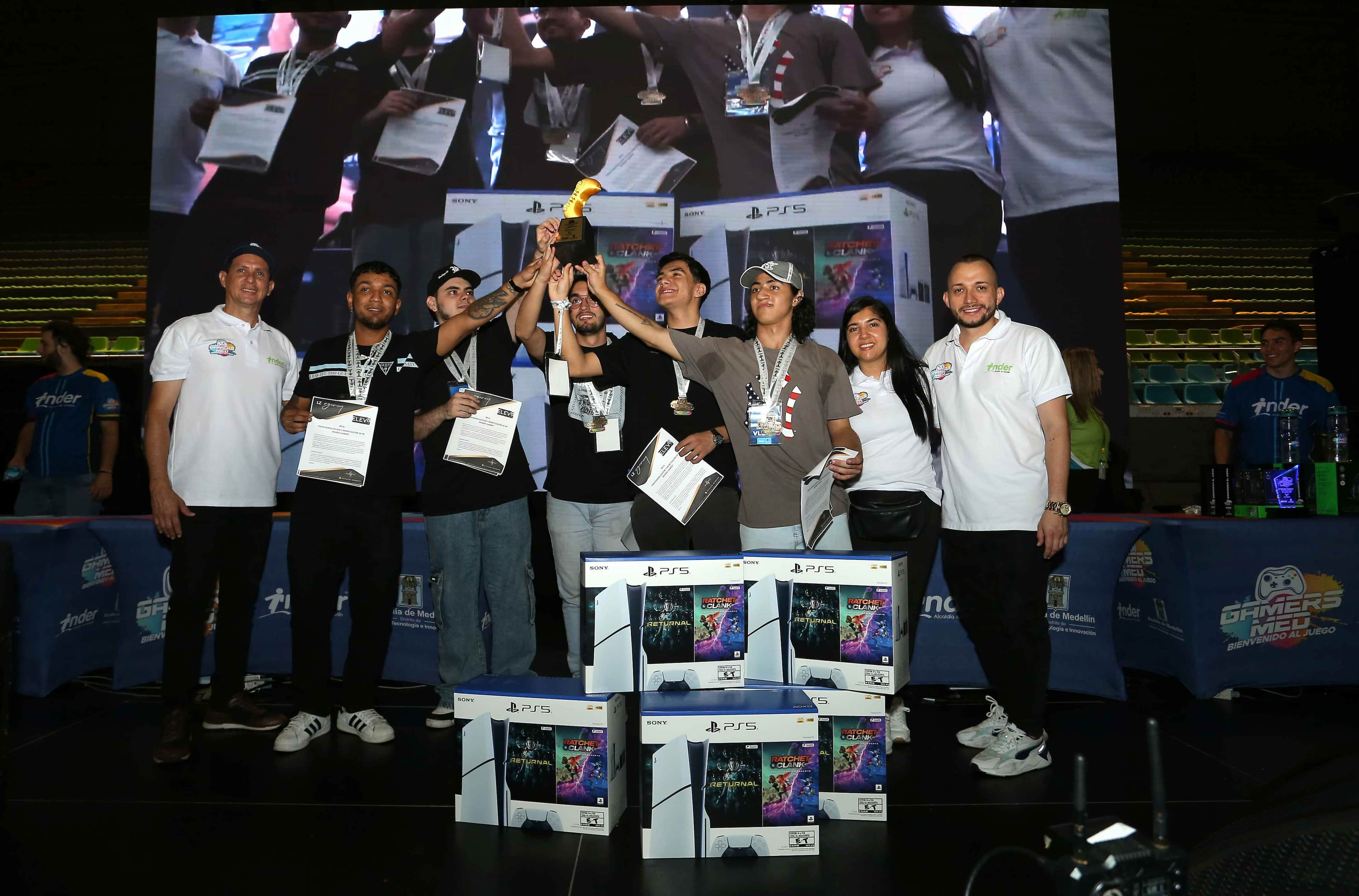 Fotografía de ganadores de Gamers MED con sus premiso y alzando su trofeo. 