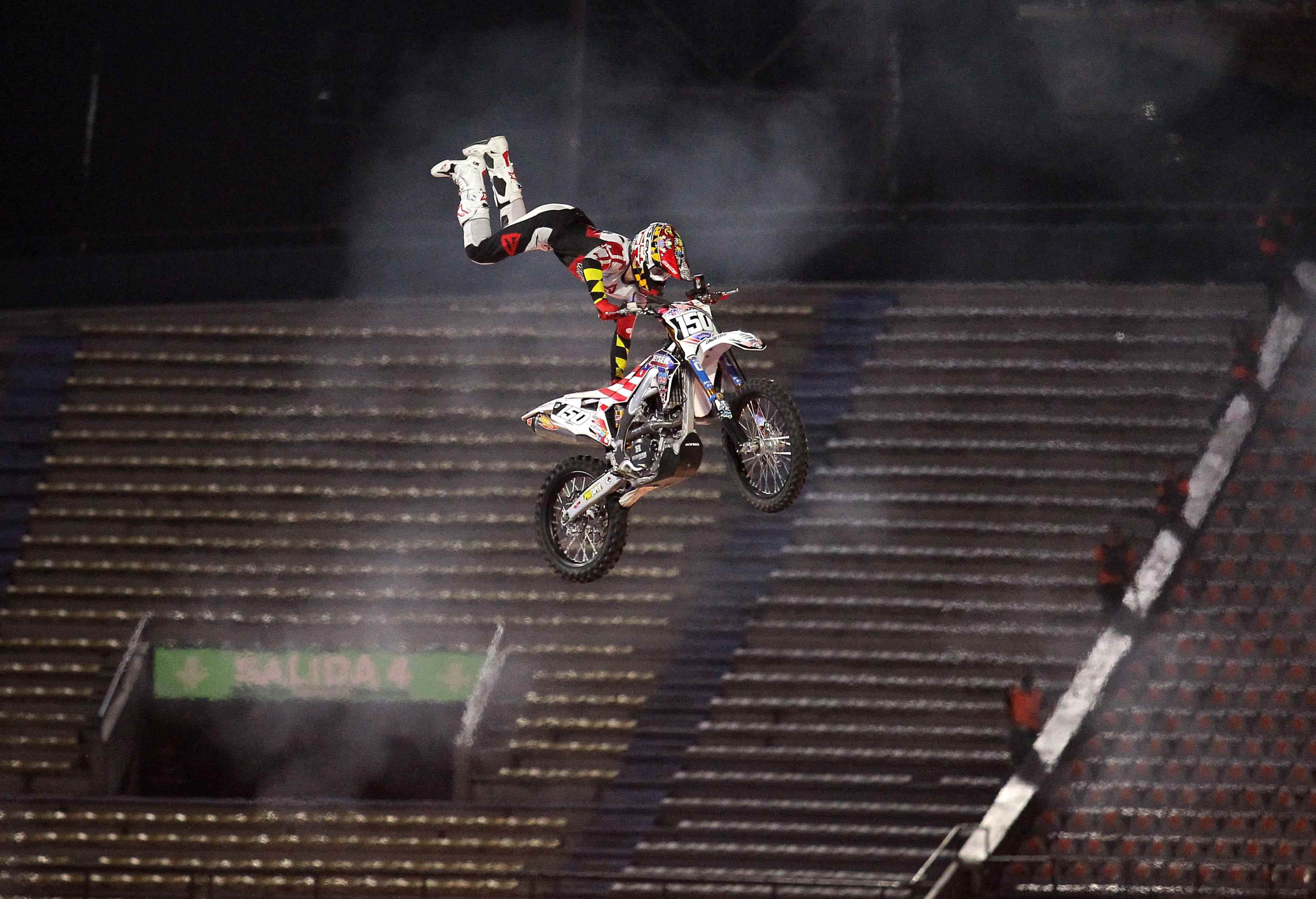 Participante de Nitro Circus en el aire con su motocicleta haciendo una acrobacia